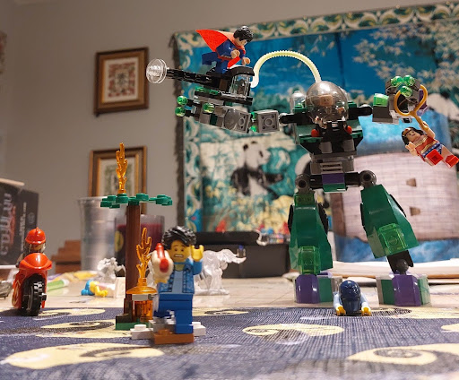 Image of legos on a table with a machine monster and city people running